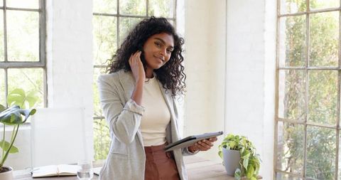 Young Professional Woman Holding Tablet in Bright Office