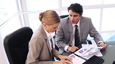 Professionals Analyzing Financial Charts in Modern Office