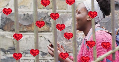 Happy Young Woman Enjoying Social Media Among Heart Balloons