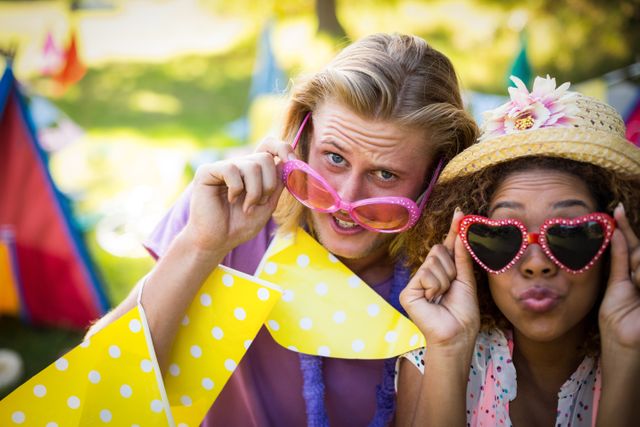 Friends having fun at a music festival in a park, wearing playful sunglasses and enjoying a sunny day. Perfect for promoting summer events, outdoor activities, youth culture, and festive gatherings.