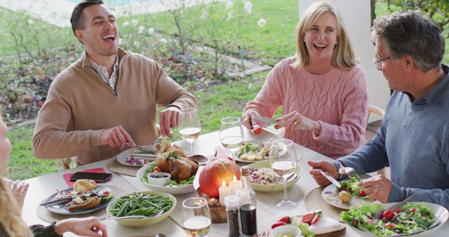 Image of happy caucasian grandfather telling story at outdoor family dinner table. Family, domestic life and togetherness concept digitally generated image.