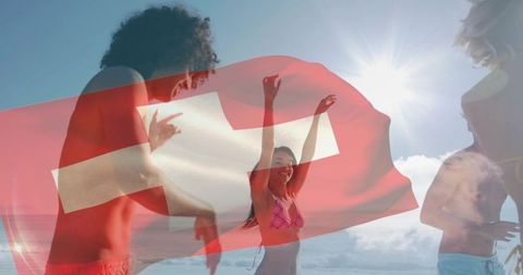 Friends celebrating summer on beach with swiss flag overlay, dancing under bright sun