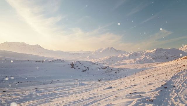 Serene winter valley with sunlit snow and distant mountains