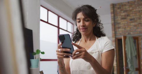 Biracial woman texting in cozy home environment