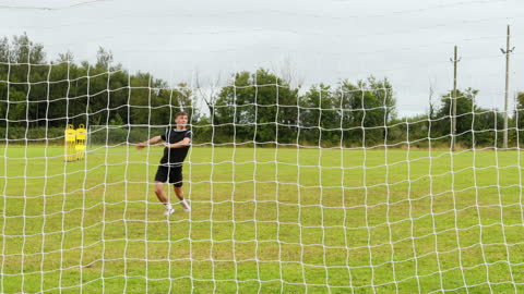 Soccer Player Practicing Goal Techniques on Sunny Field