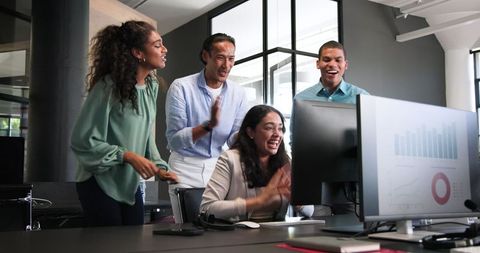 Diverse Team Celebrating Achievement, Excitement in Modern Office