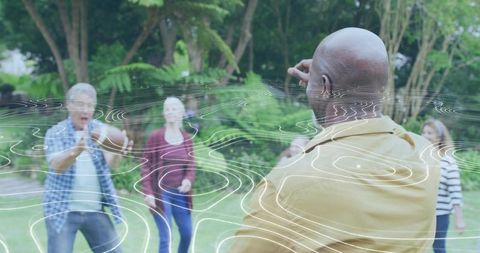 Older adults playing catch and passing football outdoors with contour overlay
