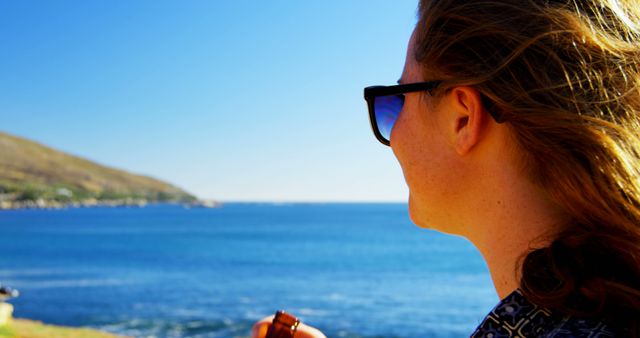 Woman Enjoying Scenic Ocean View with Sunglasses on a Sunny Day - Download Free Stock Images Pikwizard.com