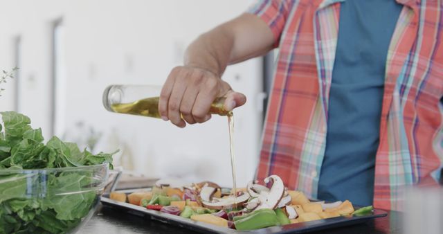 Man Pouring Olive Oil on Fresh Vegetables in Kitchen - Download Free Stock Images Pikwizard.com