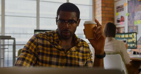 Focused Graphic Designer with Coffee Working in Modern Office