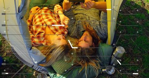 Couple Laughing on Smartphone Inside Camping Tent