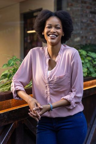 Smiling Businesswoman Leaning on Railing Checking Watch