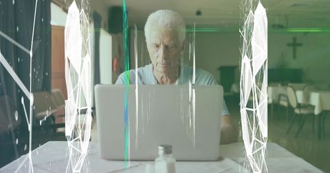 Elderly man using laptop in church community hall