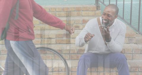 African American Senior Engaging with Smartphone and Financial Charts