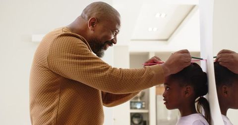 Father and Daughter Measuring Height Together at Home