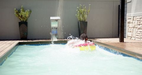 Man leisurely floating on vibrant raft in clear pool water