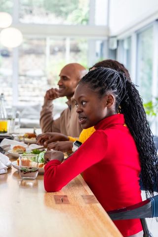 African american family enjoying breakfast and chatting at sunlit kitchen counter