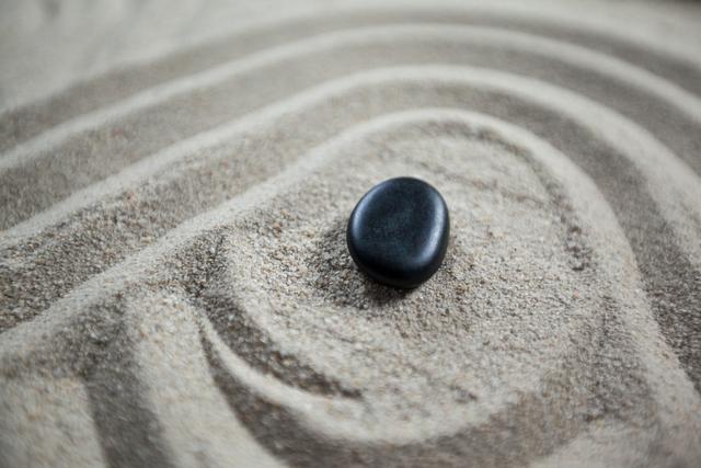 Close-up of zen garden with raked sand and stone