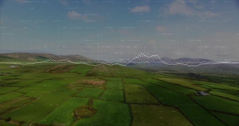 Aerial patchwork farmland with waveform overlay across green pastures and hedgerows