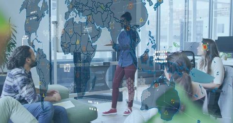 Female Presenter Gesturing at Glass World Map in Office During Data Strategy Meeting