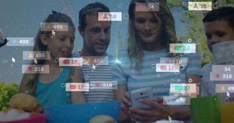 Family Using Phone at Picnic Receiving Social Media Notifications