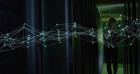 Female technician walking datacenter aisle with holographic network visualization overlay