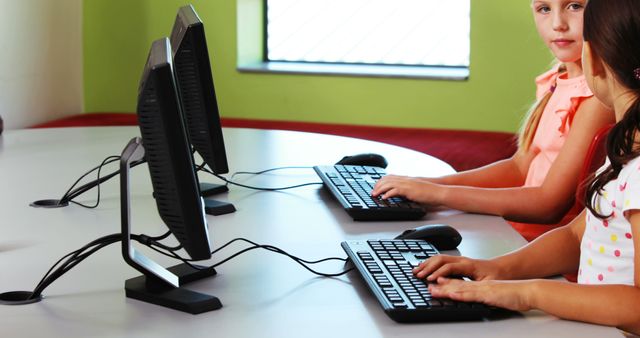 Schoolgirls using computer in classroom at school