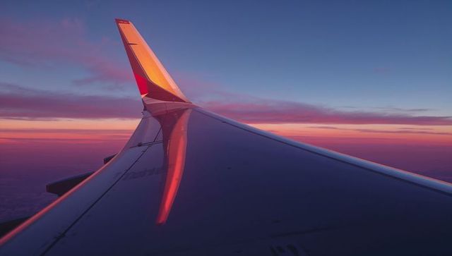 Airplane Wing Glowing at Sunrise with Vibrant Colors
