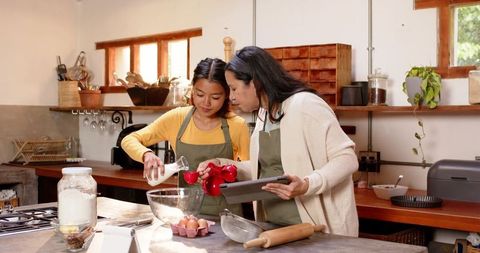 Family baking moment with mother and daughter in rustic kitchen