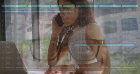 Woman speaking on phone while working on laptop with transparent data overlay