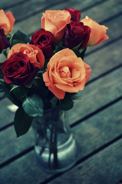 Beautiful Bouquet of Red and Orange Roses in Glass Vase on Wooden Surface - Download Free Stock Photos Pikwizard.com