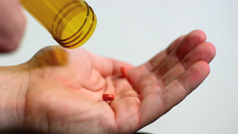 Pouring Red Tablets into Palm