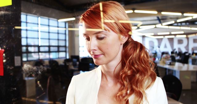 Focused Redhead Woman Writing Notes in Modern Office - Download Free Stock Images Pikwizard.com