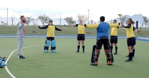 Team warm-up session in yellow jerseys on sports field