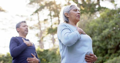 Senior Couple Meditating Outdoors in Peaceful Garden
