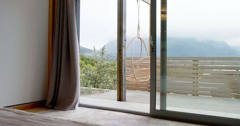Minimalist room with wicker chair and mountain view