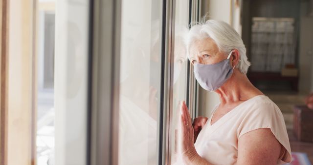 Senior Woman with Protective Mask Looking Out Window Thoughtfully - Download Free Stock Images Pikwizard.com