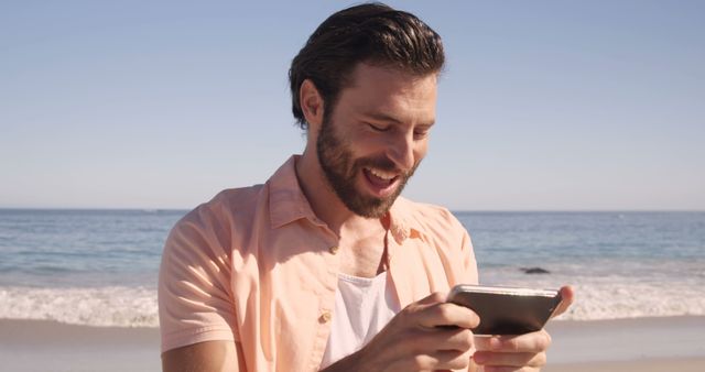 Smiling Man Texting on Smartphone at Sunny Beach - Download Free Stock Images Pikwizard.com