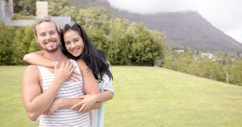 Smiling Diverse Couple Embracing in Scenic Outdoor Setting