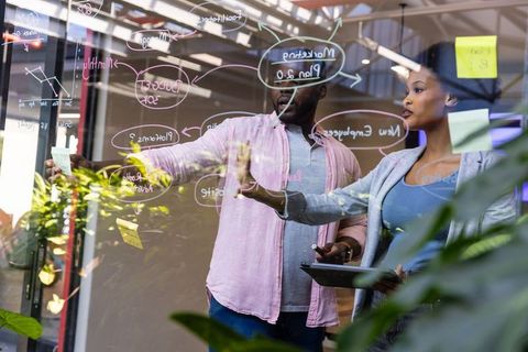 Business Team Collaborating at Office Glass Wall for Strategic Planning