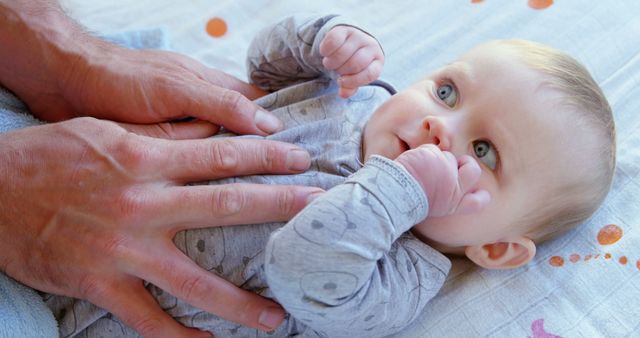 Baby Lying on Bed with Parent's Hands on Chest - Download Free Stock Images Pikwizard.com