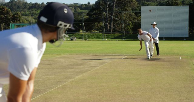 Cricketer Bowling to Batsman on Outdoor Pitch - Download Free Stock Images Pikwizard.com