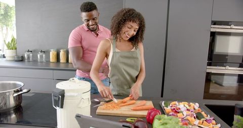 Joyful Couple Cooking Together, Creating Delicious Meal in Modern Kitchen