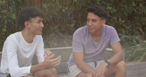 Diverse friends engaging in conversation on garden bench