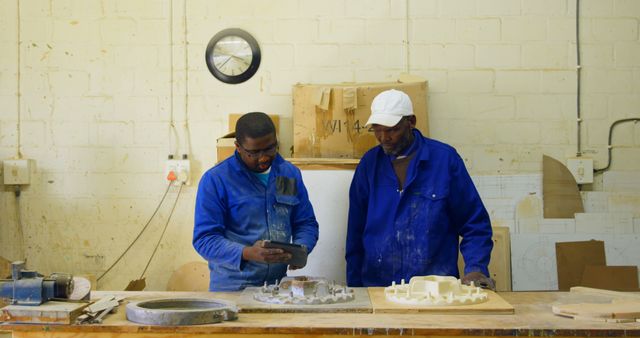 Workers Collaborating in Industrial Workshop with Digital Device - Download Free Stock Images Pikwizard.com