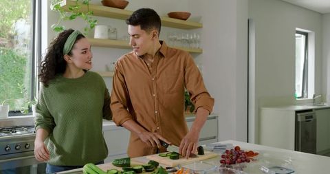 Diverse Couple Preparing Fresh Vegetables Together in Modern Kitchen