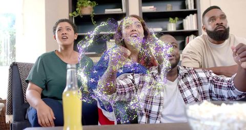 Friends watching live game cheering with sparkling digital effect, flag scarf and popcorn
