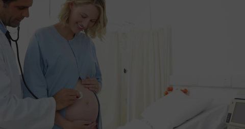 Doctor Examining Pregnant Woman with Stethoscope in Clinic