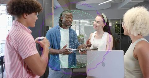 Young creative team collaborating around laptop with holographic data sphere in coworking space