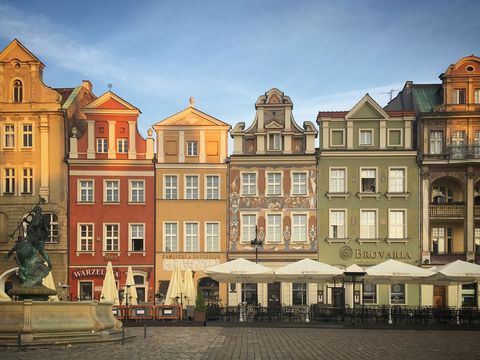 Colorful Historic Townhouses Lining European Market Square with Outdoor Cafes at Golden Hour